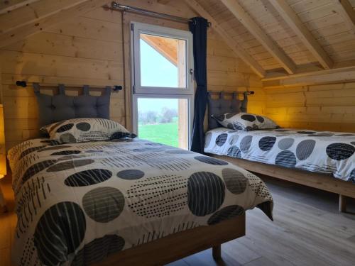 a bedroom with two beds and a window at Le P'tit Chalet - Randonnée, ski et nature près d'Evian et du Léman in Saint-Paul-en-Chablais