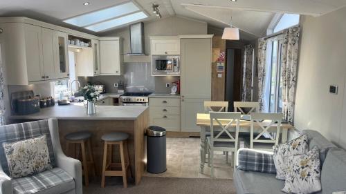 a kitchen and living room with a table and chairs at Dog Friendly Lodge with hot tub Quiet Location in Great Eccleston