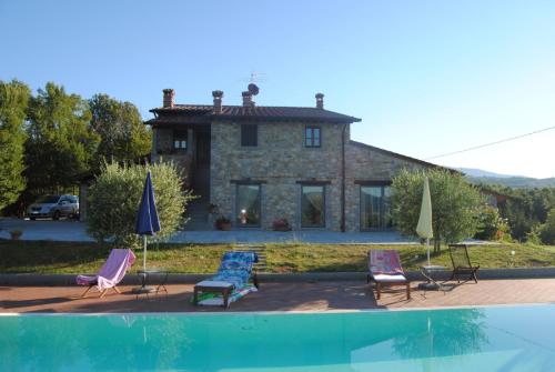 a house with chairs and a pool in front of it at Villa Castagnone in Agna