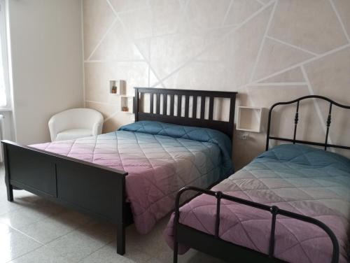 1 Schlafzimmer mit 2 Betten und einem Stuhl in der Unterkunft Casa vacanze il fiore di loto in Zibido San Giacomo
