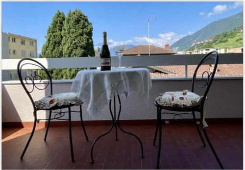 una bottiglia di vino seduta su un tavolo sul balcone di Appartamento - Tenero-Contra a Tenero-Contra