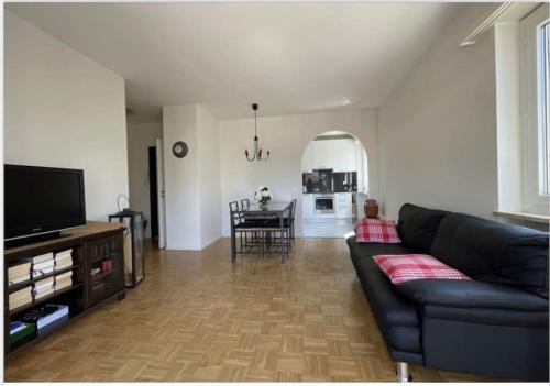 un soggiorno con divano nero e una cucina di Appartamento - Tenero-Contra a Tenero-Contra