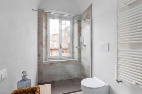 a bathroom with a toilet and a window at Dimora San Donato in Casole dʼElsa