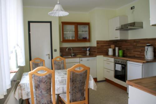 a kitchen with a table and chairs and a kitchen with a sink at Ferienwohnung Noll in Alzenau in Unterfranken