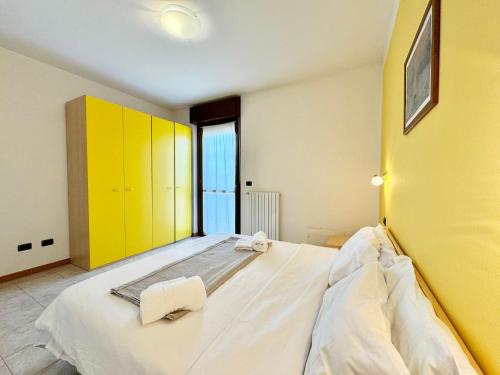 1 dormitorio con 1 cama grande y armarios amarillos en Smeraldo Retreat, en Peschiera del Garda
