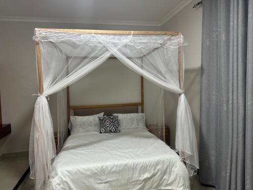 Morogoro的住宿－Winnie's Home，卧室内的一张带天蓬的床