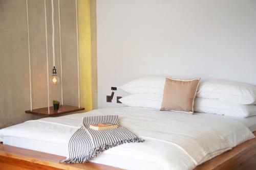 a white bed with a black and white dress on it at Flores Passport House in Ende