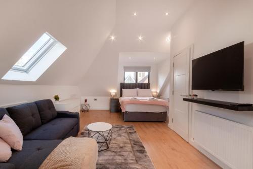 a living room with a couch and a bedroom at Cozy Studio Flat in Coulsdon, CR5 in Coulsdon