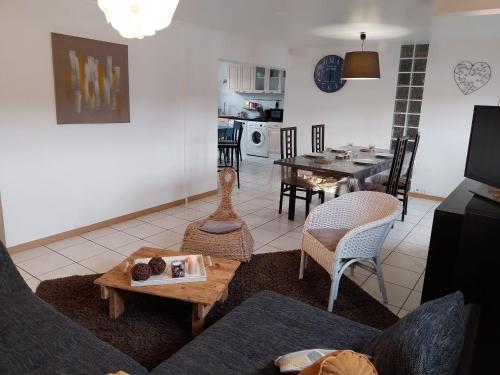 ein Wohnzimmer mit einem Sofa und einem Tisch in der Unterkunft Glycine in Le Petit-Quevilly