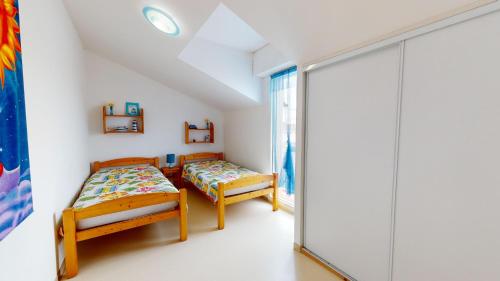 deux lits dans une chambre avec une fenêtre dans l'établissement Le Jardin de la mer 150 plage, à Plage-des-Demoiselles