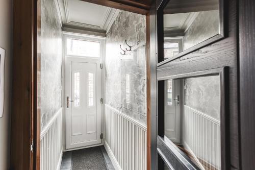 a hallway of a house with a white door at Helter Skelter Matlock in Matlock