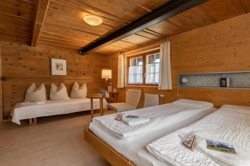 a bedroom with two beds in a room with wooden walls at Gasthaus Rössli in Mogelsberg