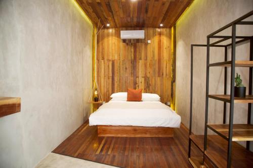 - une chambre avec un lit et un mur en bois dans l'établissement Flores Passport House, à Ende