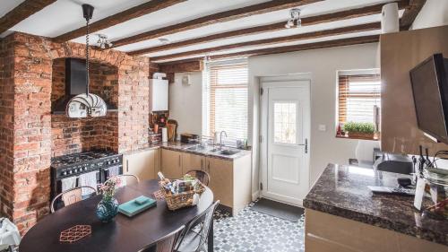 a kitchen with a brick wall and a counter top at Helter Skelter Matlock in Matlock