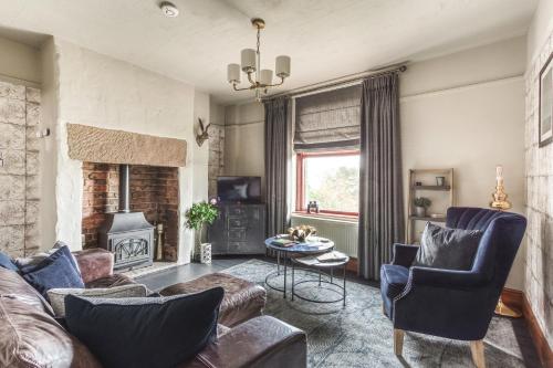 a living room with a couch and chairs and a fireplace at Helter Skelter Matlock in Matlock