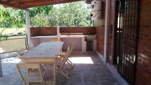 a wooden table and chairs on a patio at LAPACHO II in Puerto Leoni