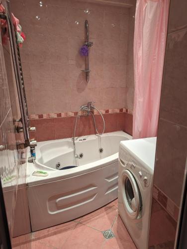 ein Badezimmer mit einer Badewanne und einer Waschmaschine in der Unterkunft ქირავდება თბილისში, დიდუბის პავილიონთან 2 ოთხაიანი ბინა in Tbilisi City