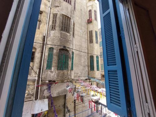 a window view of a building with tables and umbrellas at Alexandria private rooms, Only For Men 仅限男士 in Alexandria