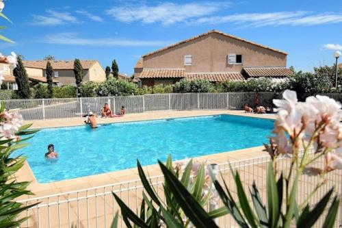 a swimming pool in front of a house at L'échapée Belle - Villa, résidence avec piscine et stationnement à proximité de la mer in Vendres