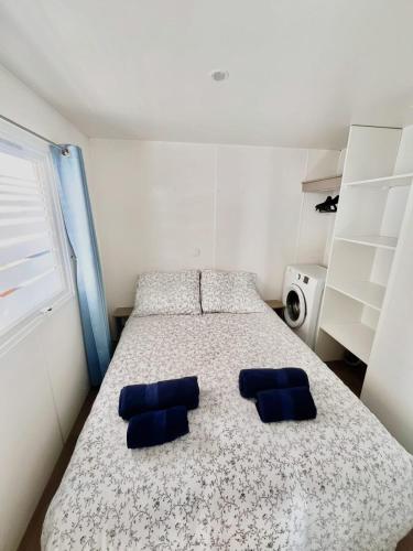 une chambre avec un lit avec deux oreillers bleus dans l'établissement Mobil Home Abricotiers 1, à Valras-Plage