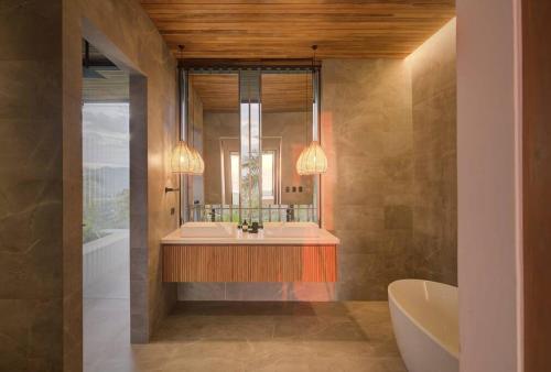 een badkamer met een bad, een wastafel en een spiegel bij Casa Con Vista – Nosara, Guanacaste, Costa Rica. S in Nosara