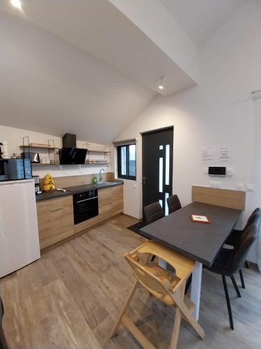 une cuisine et une salle à manger avec une table et des chaises dans l'établissement le chalet d Alex, à Étretat
