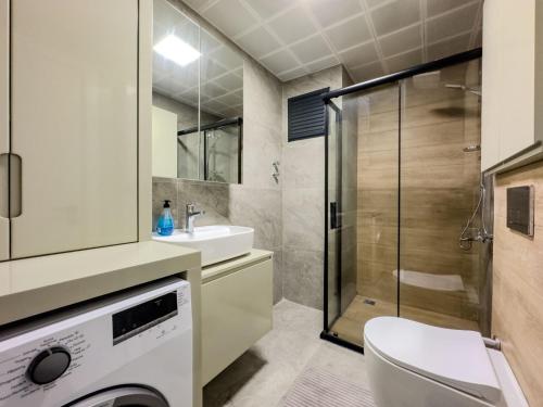 La salle de bains est pourvue de toilettes, d'un lavabo et d'une douche. dans l'établissement Antalya Havalimanına Yakın Havuzlu 1+1 Lux Daire, à Antalya