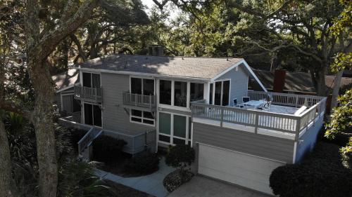 a tiny house with a porch and a deck at OCEAN RETREAT home in Jekyll Island