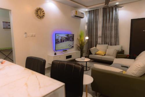 a living room with a couch and a tv at CMP APARTMENTS in Kasoa