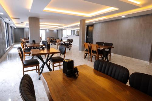 un ristorante con tavoli e sedie in legno, tavoli e sedie e chairsktop di Meyzi Hotel a Istanbul