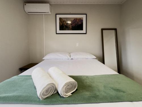 ein Schlafzimmer mit einem weißen Bett und Handtüchern darauf in der Unterkunft Casa com visão panorâmica no centro de Nova Trento in Nova Trento