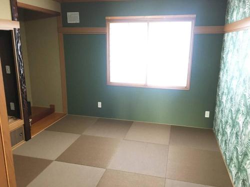 an empty room with a window and a tiled floor at 千歳空港まで30分/Casa Cotaro（カーサ・コタロ）/最大8名まで宿泊可能/近隣飲食店多数有 in Naganuma