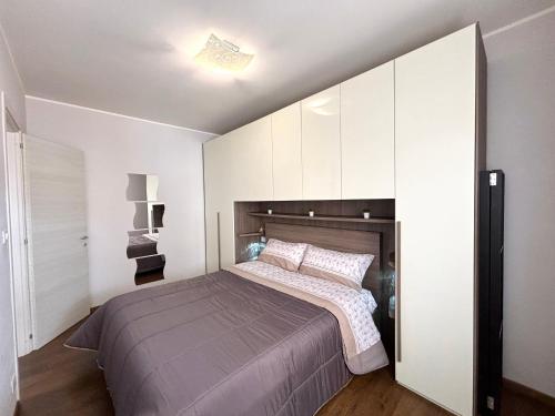 una camera con un grande letto e una parete bianca di Cavalluccio Marino i4 Silvi Vacanza a Silvi Marina