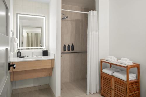 a bathroom with a sink and a shower with a mirror at Sheraton Sand Key Resort in Clearwater Beach