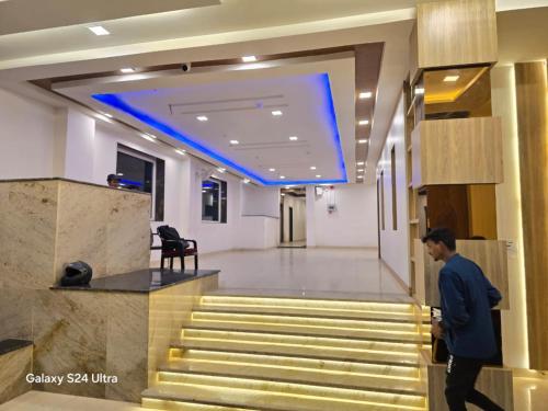 a man walking down the stairs in a lobby at Kashi Inn Raj Ghat Varanasi BY GRG in Varanasi