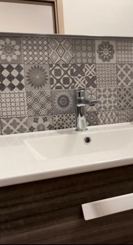 bagno con lavandino e parete piastrellata di Baglio Eldama a Castelvetrano Selinunte
