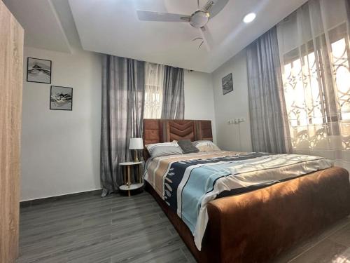 a bedroom with a large bed and a window at CMP APARTMENTS in Kasoa