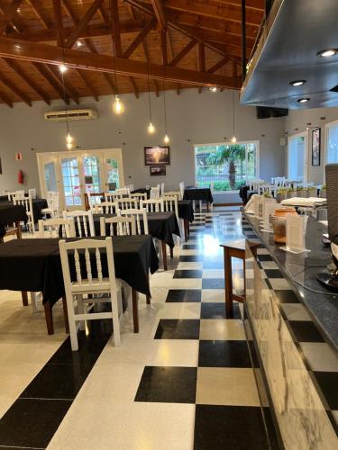 a dining room with black and white tables and chairs at Garden House Hotel in Río Cuarto