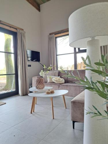 a living room with a couch and a table at De Wijnlodge in Kootwijkerbroek