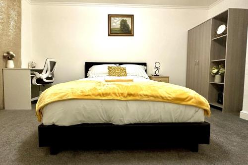 a bedroom with a bed with a yellow blanket on it at Comfy Room in Nottingham in Nottingham