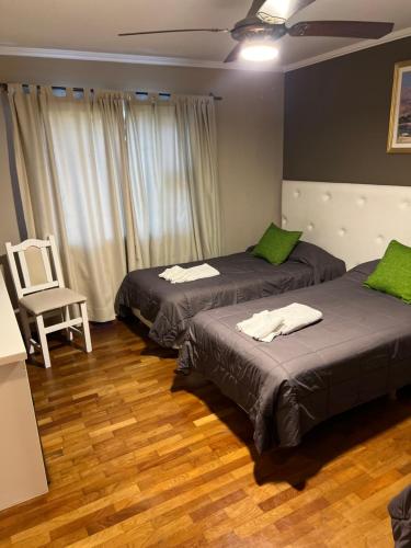 a room with two beds and a chair in it at Garden House Hotel in Río Cuarto