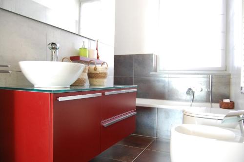 łazienka z czerwoną szafką i umywalką w obiekcie Monferrato Asti-luminosa villa w mieście CastellʼAlfero