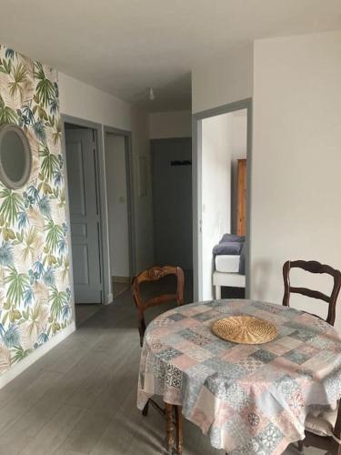 une salle à manger avec une table et deux chaises dans l'établissement Appartement cosy Pleine Fougères, à Pleine-Fougères