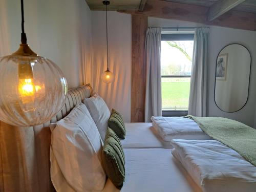 een slaapkamer met een bed met kussens en een raam bij De Wijnlodge in Kootwijkerbroek
