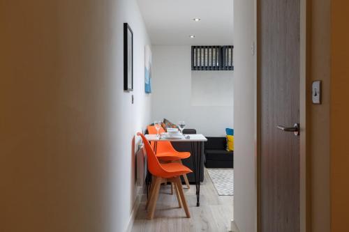 comedor con mesa y sillas naranjas en One-Bedroom Apartment in Conditioning House, en Bradford
