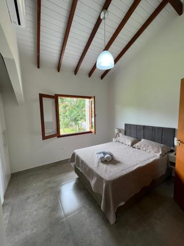 a bedroom with a bed and a window at Casa Maritaca in Paraty