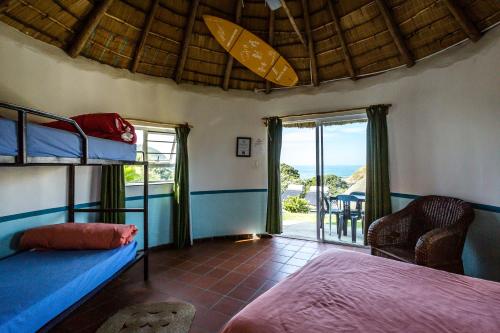 a bedroom with a bunk bed and a balcony at Coffee Shack Adventure Backpackers & Self-Catering in Coffee Bay