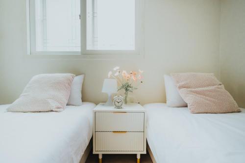 Dos camas una al lado de la otra en un dormitorio. en DK House, en Seúl