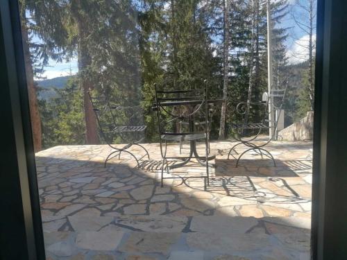 un patio con mesa y sillas en un suelo de piedra en Vila Plava Zlatar en Brdo