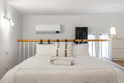a white bedroom with a large bed with white pillows at New 2024 Urban 48 in Cagliari